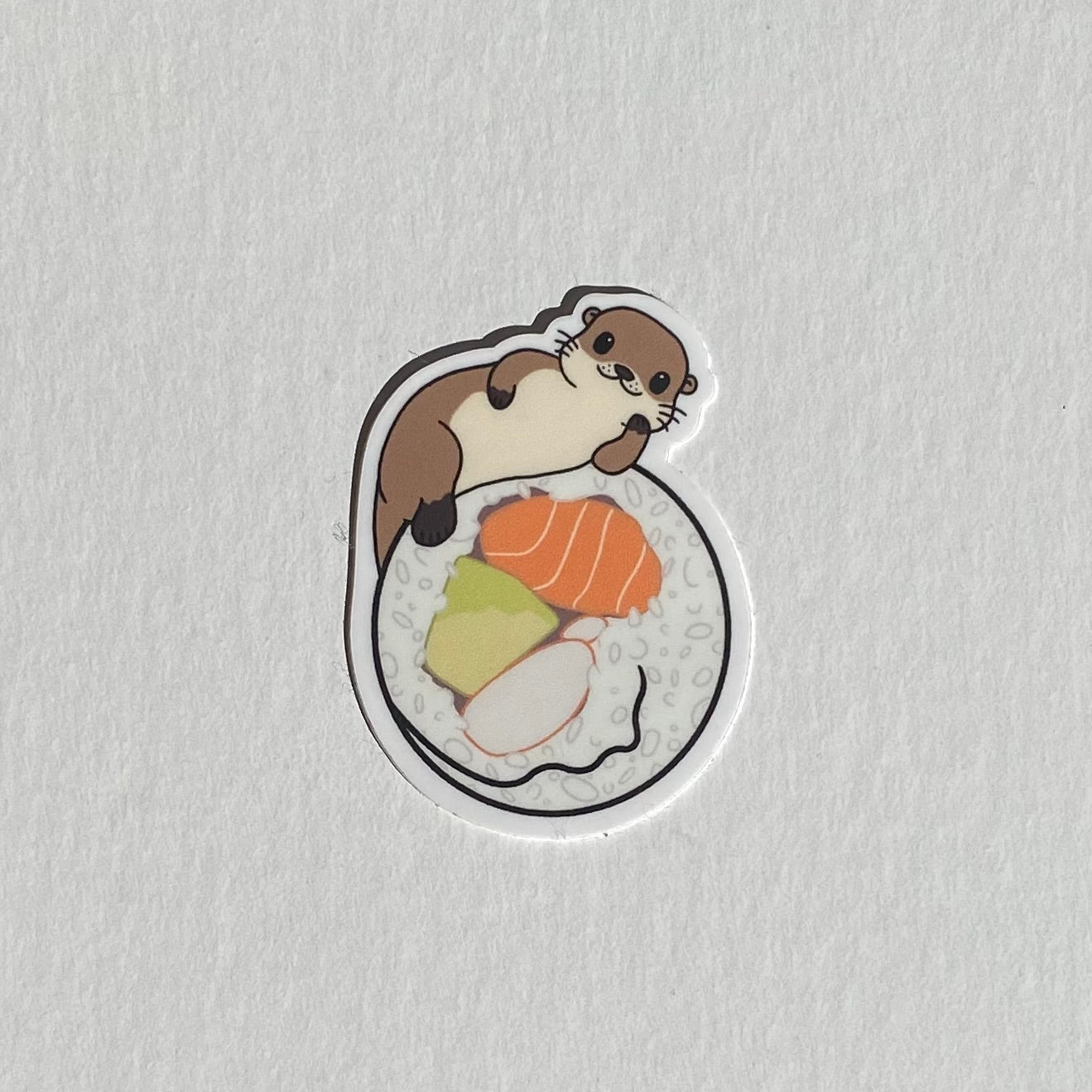 Sushi roll. Sushi roll sticker. Sea otter sticker. Cute sticker. White background.